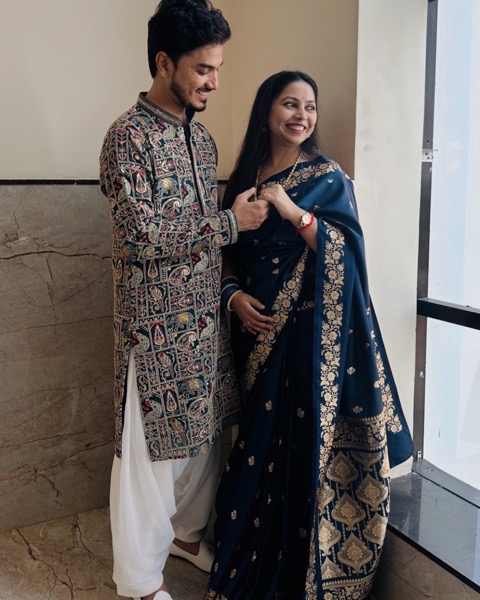 The two of us in traditional outfits by a tall window