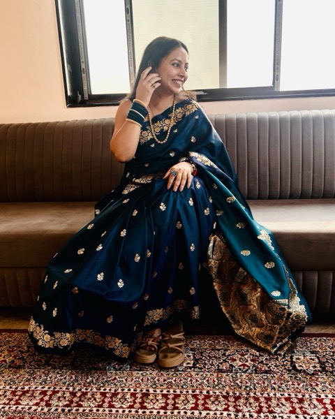 Seated in a navy saree with gold motifs